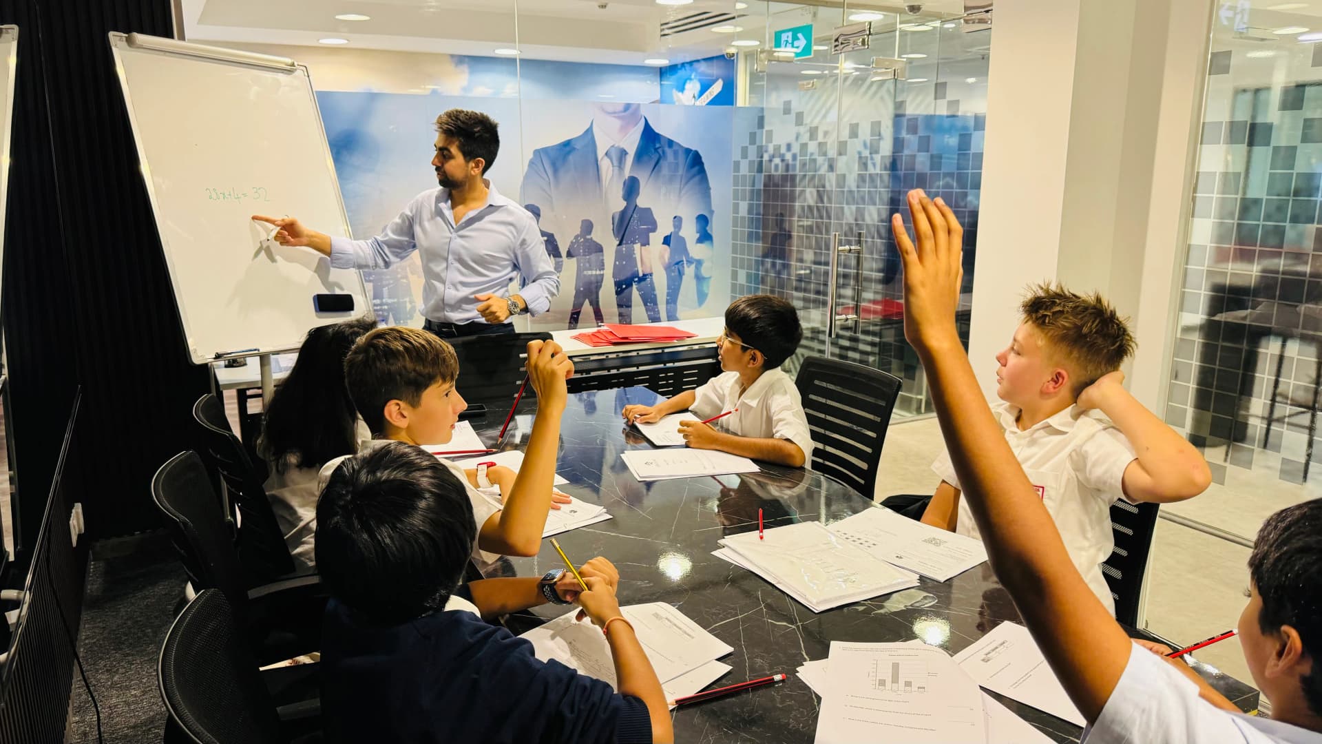 A teacher guiding pupils during a CAT4 preparation lesson at Improve ME Institute