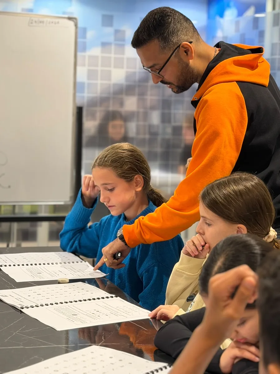 A teacher pointing out a reasoning question to a pupil during a CAT4 workshop